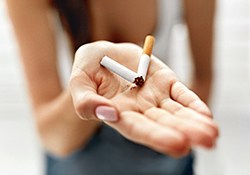 Quitting smoking, close-up of broken cigarette in woman’s palm