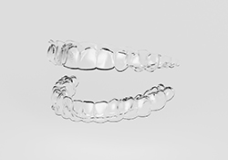 Clear aligners for top and bottom teeth against neutral background