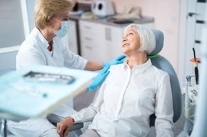 compassionate dentist and older female patient discussing treatment