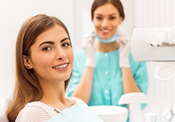 Patient with professional braces smiling during dental appointment