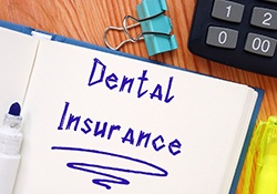 Dental Insurance written in blue ink in notebook