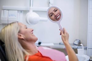 Dental patient smiling in mirror