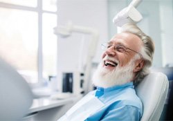 Laughing older man in dental treatment chair
