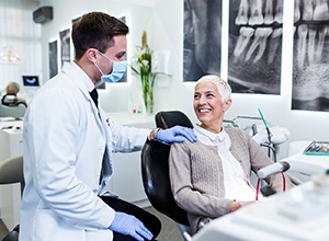 mature female dental patient happy after receiving denture