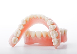 Two full dentures, carefully arranged against neutral background