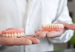 Dentist holding upper and lower dentures