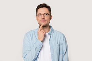 Man in denim shirt with questions about emergency dentistry 