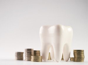 Large tooth model surrounded by stacks of coins