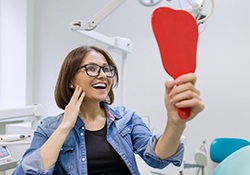 young woman admiring her new dental implants in Newington