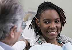 smiling patient learning about the cost of dental implants in Newington