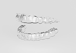 Clear aligners for top and bottom teeth against neutral background