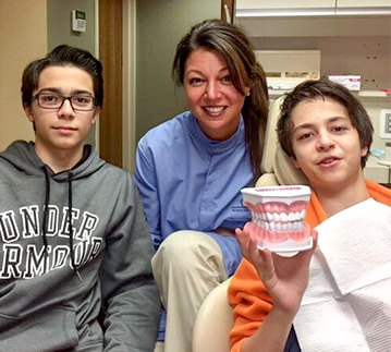 Dental team member and two teenage boys in exam room