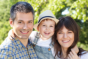 Mother father and child smiling outdoors