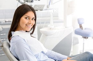 woman in dental chair showing her healthy smile