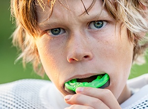 Teen boy placing athletic mouthguard