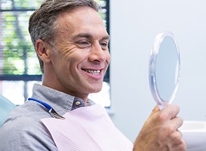 man smiling while looking in mirror