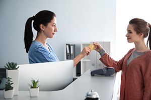 Patient using card to pay for dental care