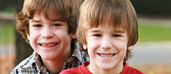 Two young boys smiling outdoors