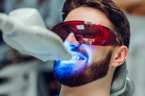 Man relaxing while undergoing in-office whitening treatment