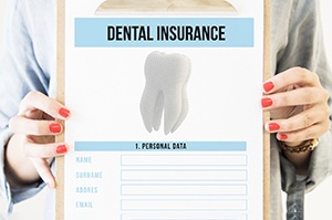 Woman holding clipboard with dental insurance information