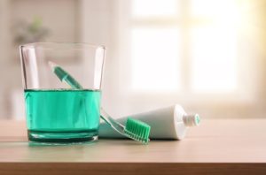 toothbrush and toothpaste next to mouthwash — dental hygiene tools