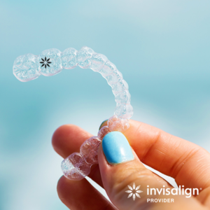 Close-up of hand holding aligner to celebrate Invisalign promotion