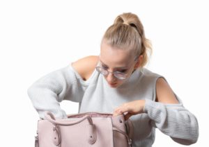 Woman carefully searching purse for lost aligner for Invisalign in Newington