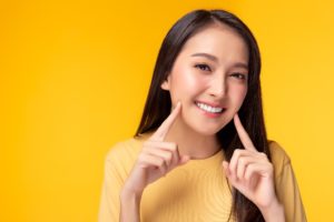 Woman showing her smile after free teeth whitening treatment