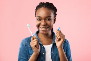 Woman with braces holding tools for oral hygiene