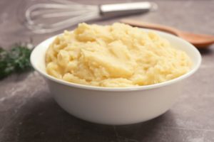 Serving of mashed potatoes in white bowl