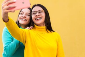 Two teens with braces taking a selfie