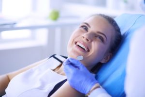 Smiling patient looking upward at dental team member