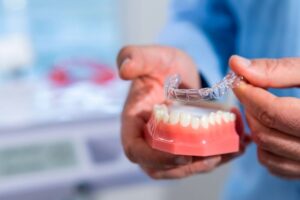 Dental team member using model to discuss Invisalign