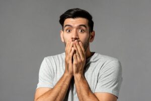 Shocked man covering his mouth