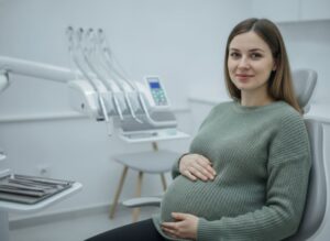 Pregnant woman sitting in dental treatment chair