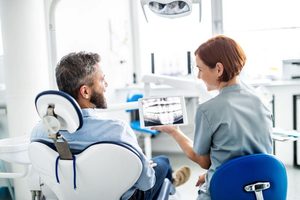 Dentist and patient talking during checkup 
